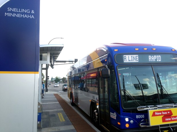 A city bus stopped at a bus stop.